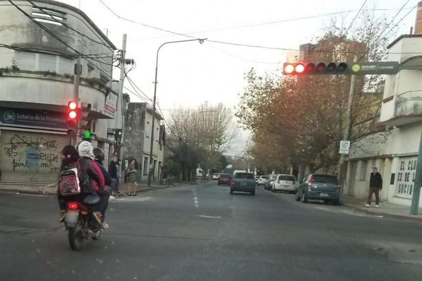 Pareja de motociclistas con dos nios a bordo cruz varios semforos en rojo
